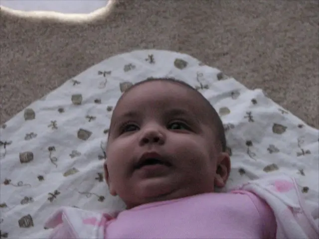 In this picture we can see a baby on the cloth.