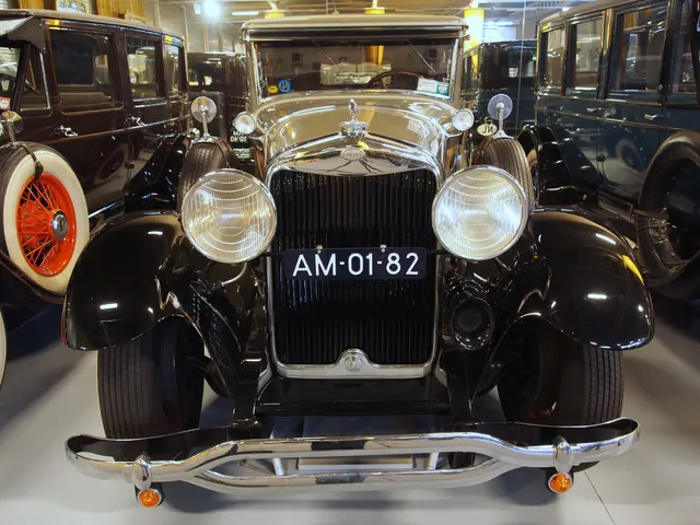 The image shows a group of vintage cars on display in a museum, with a number plate on one of them....