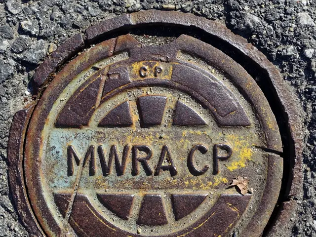 The image shows a rusty metal manhole cover on the ground with the words "MWRA CP" inscribed on it.