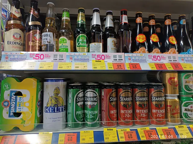 The image shows a shelf filled with lots of different types of beer, including bottles and tins,...