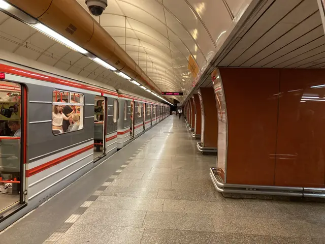 The image shows a subway train pulling into a station next to a platform, with people inside the...