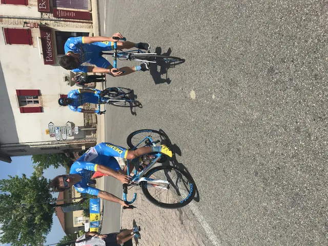 The image shows a group of people riding bicycles down a street, with a building on the left side...