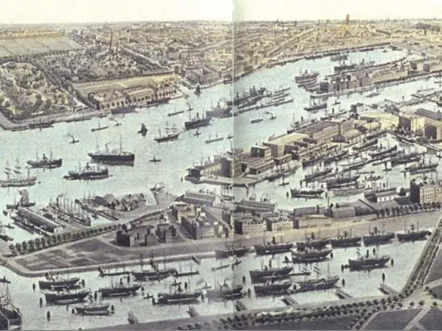 The image shows an aerial view of a city with lots of boats in the water, as well as buildings and...