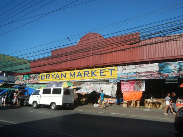 The image shows a bustling bazaar with vehicles on the road, people walking on the footpath,...