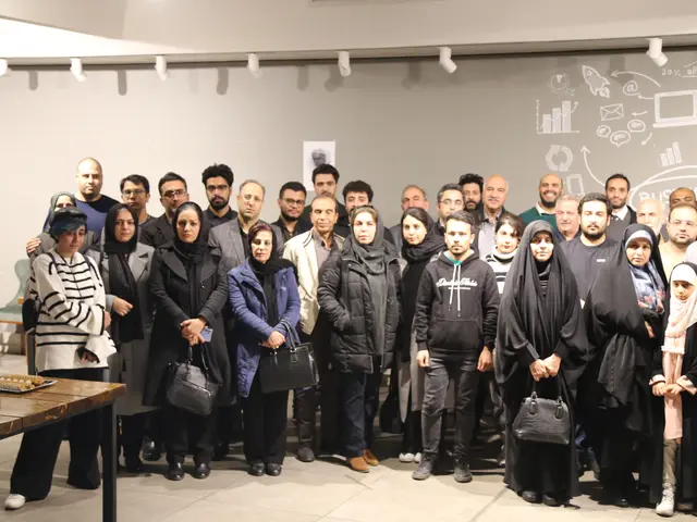 The image shows a group of people standing next to each other in front of a table with water...