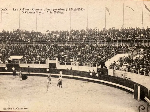 The image shows an old black and white photo of a boxing match in a stadium, with a group of people...