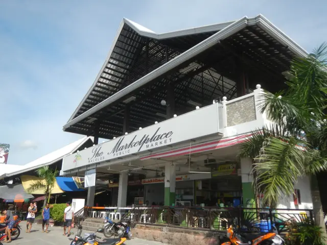 The image shows the marketplace public market in Koh Samui, Thailand, with a group of people...