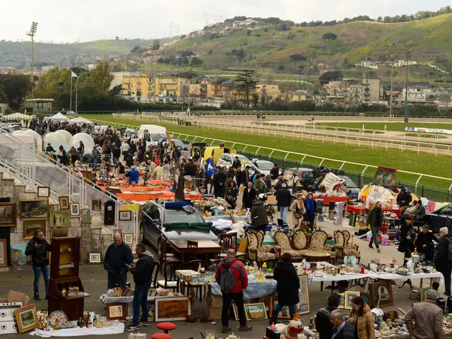 The image shows a large group of people standing around a flea market, with tables filled with...