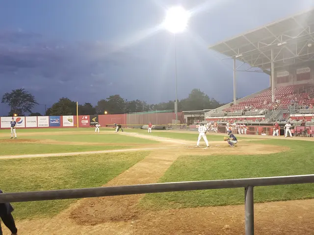 The image shows a baseball game being played in a stadium, with people sitting in the stands on the...