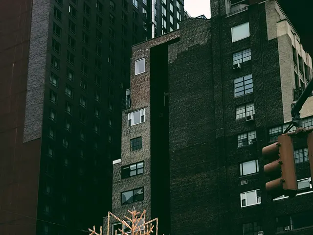 The image shows a city street with tall buildings in the background, a tree in the foreground, and...