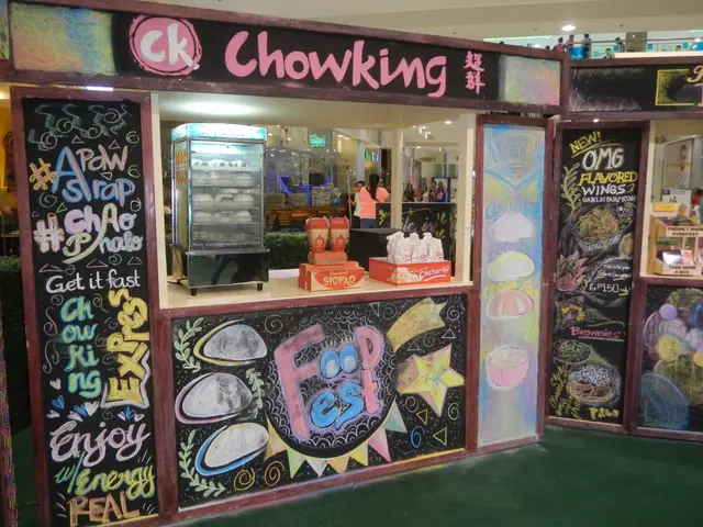 The image shows a chowking food stand at the Mall of Asia, with a group of people standing in front...