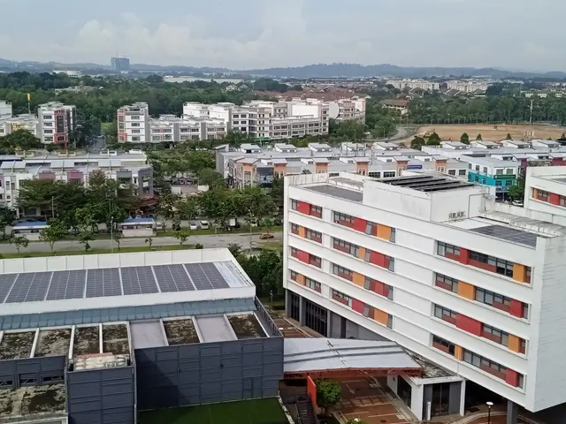 The image shows a view of a city from the top of a building, with solar panels on the roof. We can...