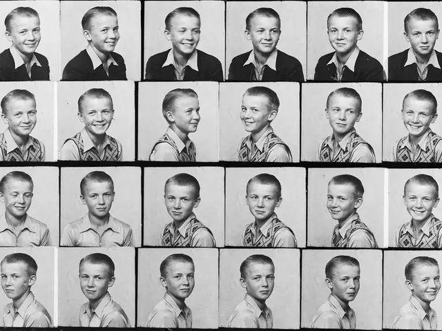 The image shows a black and white photo of a young boy with a big smile on his face. His hair is...