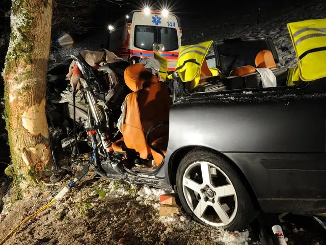 The image shows a car that has been involved in a crash on the side of the road, with an ambulance...