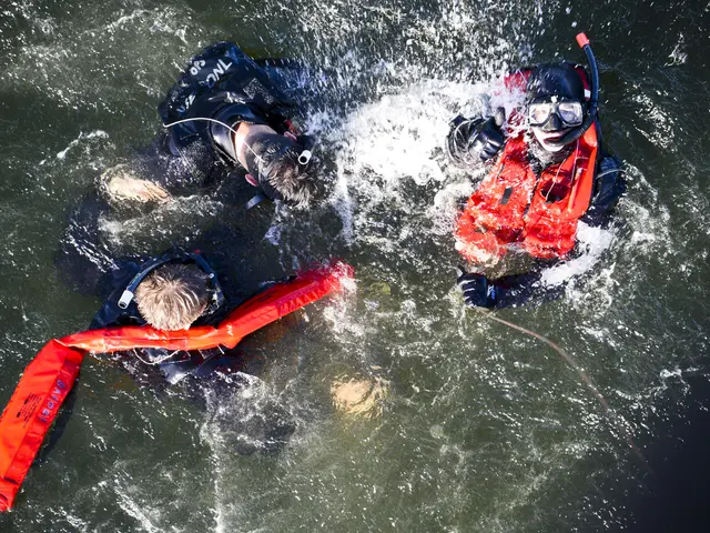 The image shows two people in the water wearing life jackets and swimming goggles, with one of them...