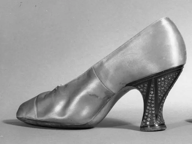 The image shows a black and white photo of a pair of women's shoes from the 1930s. The shoes have a...