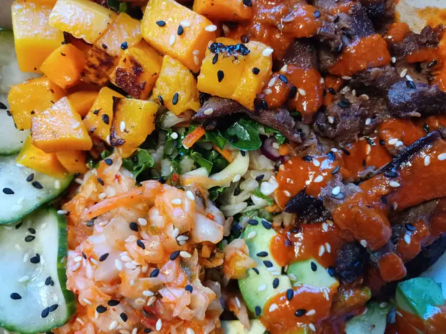 The image shows a close up of a bowl filled with a variety of vegetables and meat, likely from one...