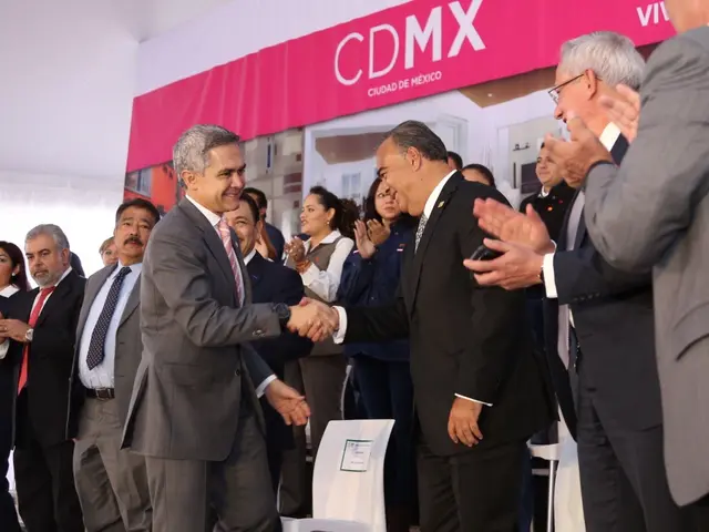 The image shows a group of people standing around each other in front of a sign that reads "CDMX"....