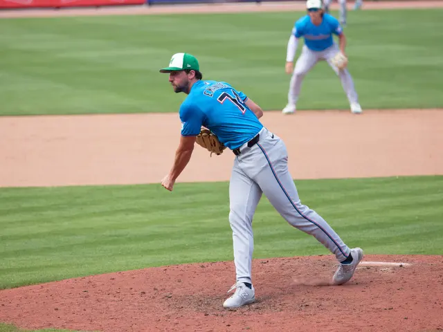 The image shows a baseball player pitching a ball on top of a field. The player is wearing a blue...