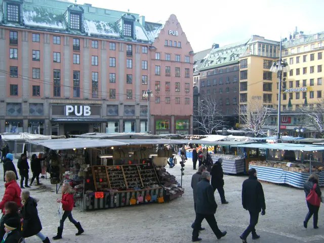 The image shows a bustling Christmas market in Stockholm, Sweden. There are many people walking...
