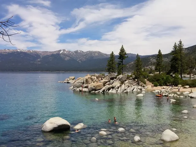 The image shows a stunning view of Lake Tahoe in California, with people swimming in the crystal...