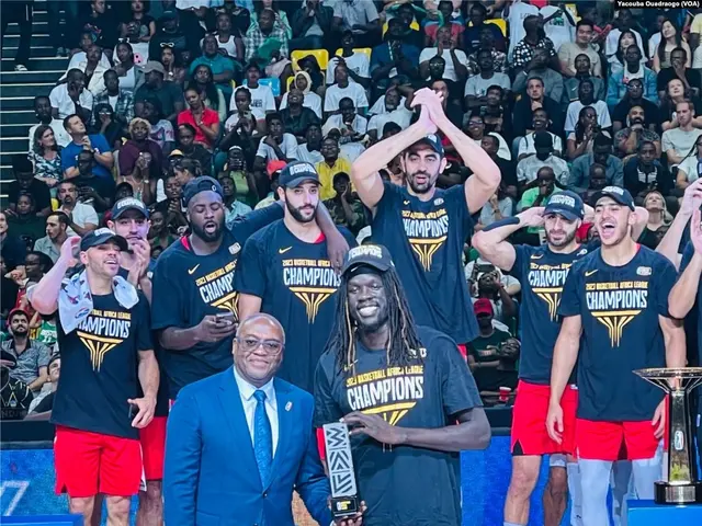 The image shows a group of men standing on top of a basketball court, with two of them holding...