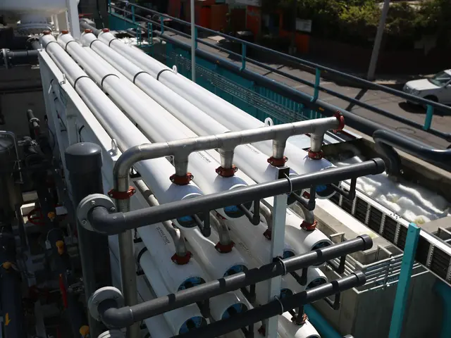 The image shows a large group of pipes and valves sitting on top of a building, surrounded by...