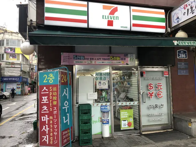 The image shows a 7-eleven convenience store in Seoul, South Korea. There are vehicles on the road...