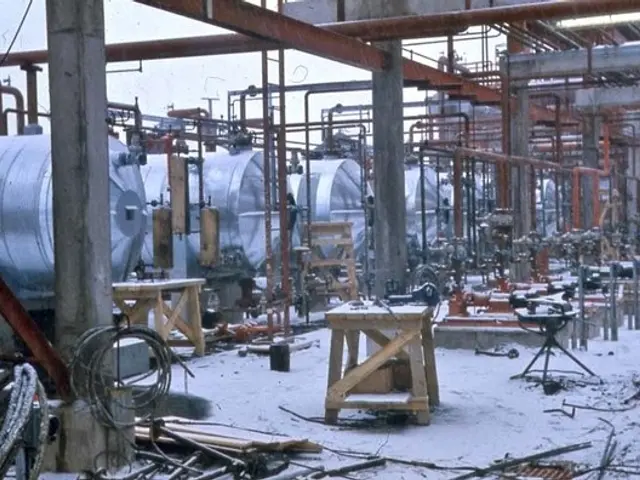 The image shows a large factory filled with lots of machines, poles, wires, tables, and other...