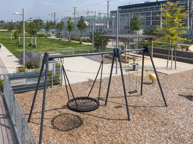 The image shows a playground with a swing set in the middle of it surrounded by trees, plants,...
