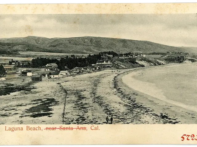 The image shows a black and white photo of Laguna Beach, near Santa Ana, California. It features a...