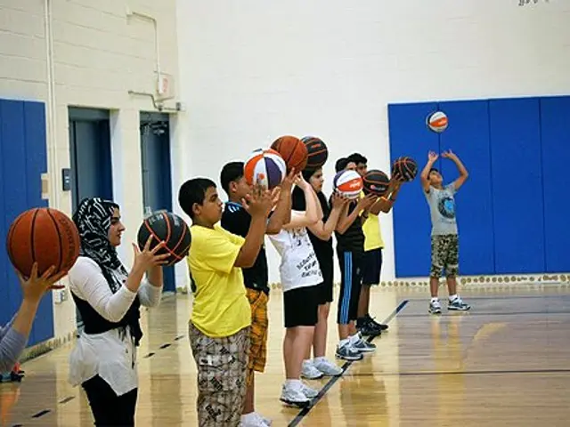 The image shows a group of young people standing on top of a basketball court, each holding a...