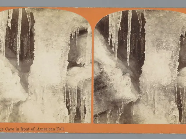 The image shows an old photo of an ice cave in the front of an American fall, with icicles hanging...