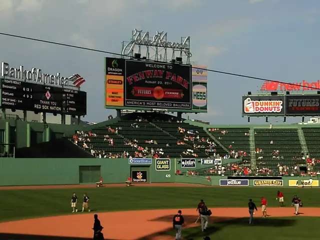 The image shows Fenway Park, home of the Boston Red Sox, with a group of people playing baseball on...
