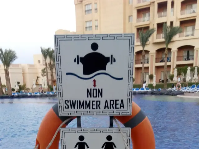 The image shows a swimming pool with a sign that reads "Non Swimmer Area Adults Only" in the...