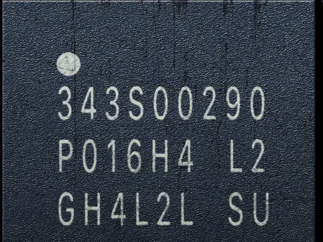 The image shows a close up of a black and white photo of a chip with numbers and text on it. The...