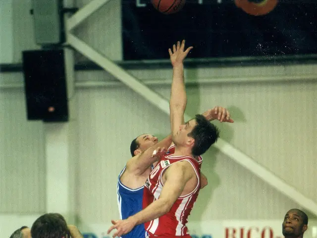The image shows a group of men playing a game of basketball on a court, with a wall in the...