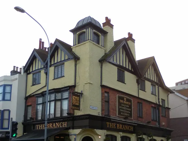 The image shows the Branch Pub in London, England. It is a building with windows, a signboard with...