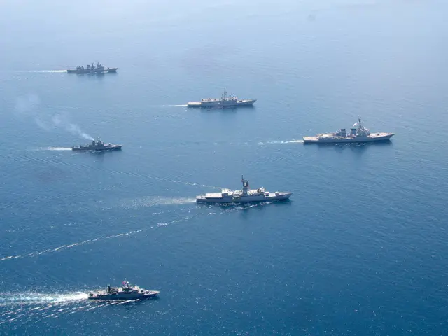 The image shows a group of ships sailing in the ocean, with the sky in the background. The ships...