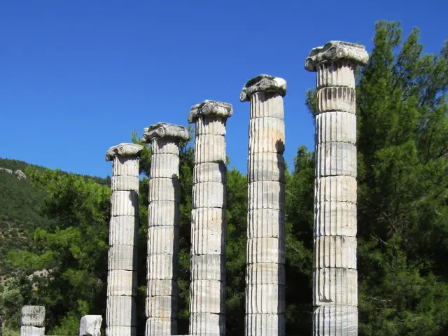 The image shows the Temple of Olympian Zeus in Delphi, Greece, with its iconic pillars, rocks,...