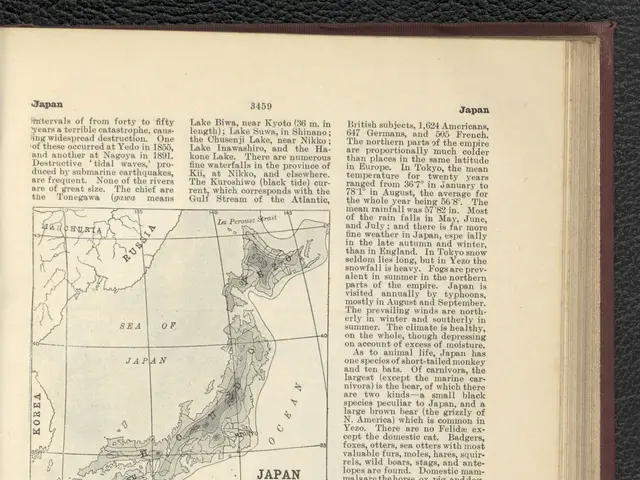 The image shows an open book with a map of Japan on it, placed on a black surface. The book...