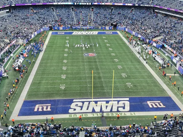 The image shows a football stadium filled with lots of people watching a game. On the ground, there...