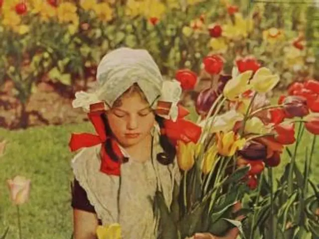 The image shows a woman standing in a garden, holding a bouquet of tulips in her hands. The garden...
