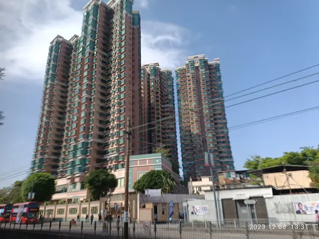 The image shows a bustling city street with tall buildings in the background. There are vehicles on...