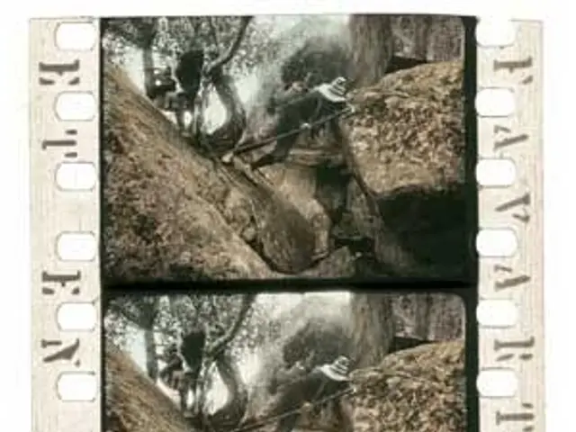 The image shows a black and white photo of a group of people climbing up a rocky cliff, with trees...