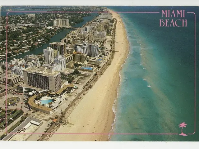 The image shows an aerial view of Miami Beach, Florida, with buildings, trees, roads, vehicles, and...