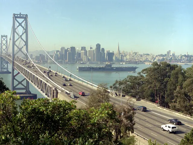 The image shows the iconic Bay Bridge in San Francisco, California, with vehicles driving across...