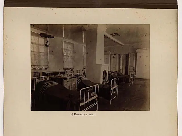 The image shows an old black and white photo of a hospital room with two pictures of beds, tables,...