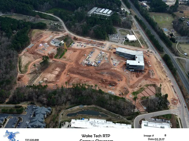 The image shows an aerial view of a construction site in the middle of a city, with buildings,...