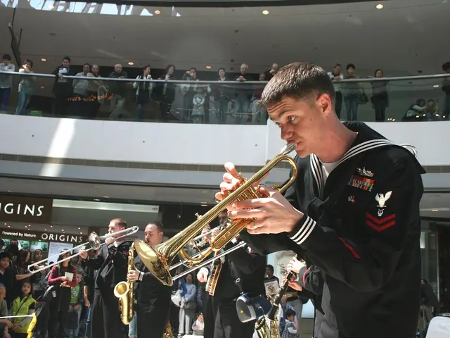 The image shows a man in a military uniform playing a trumpet in front of a crowd of people, some...